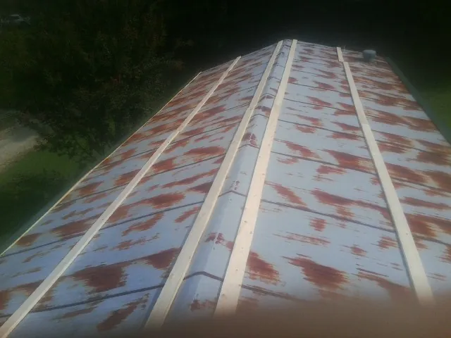 Rusted metal roof panels with new wood purlins before replacement — Storm Damage Roof Repair in Colonial Beach by Roofing Brothers