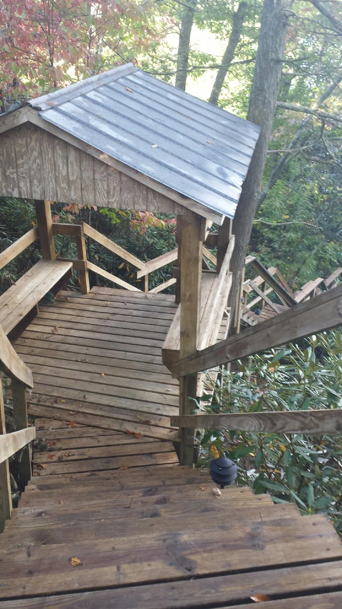 Metal roofed shelter over wooden steps on a wooded walkway — Skylight Repair & Installation work by our crew in Colonial Beach