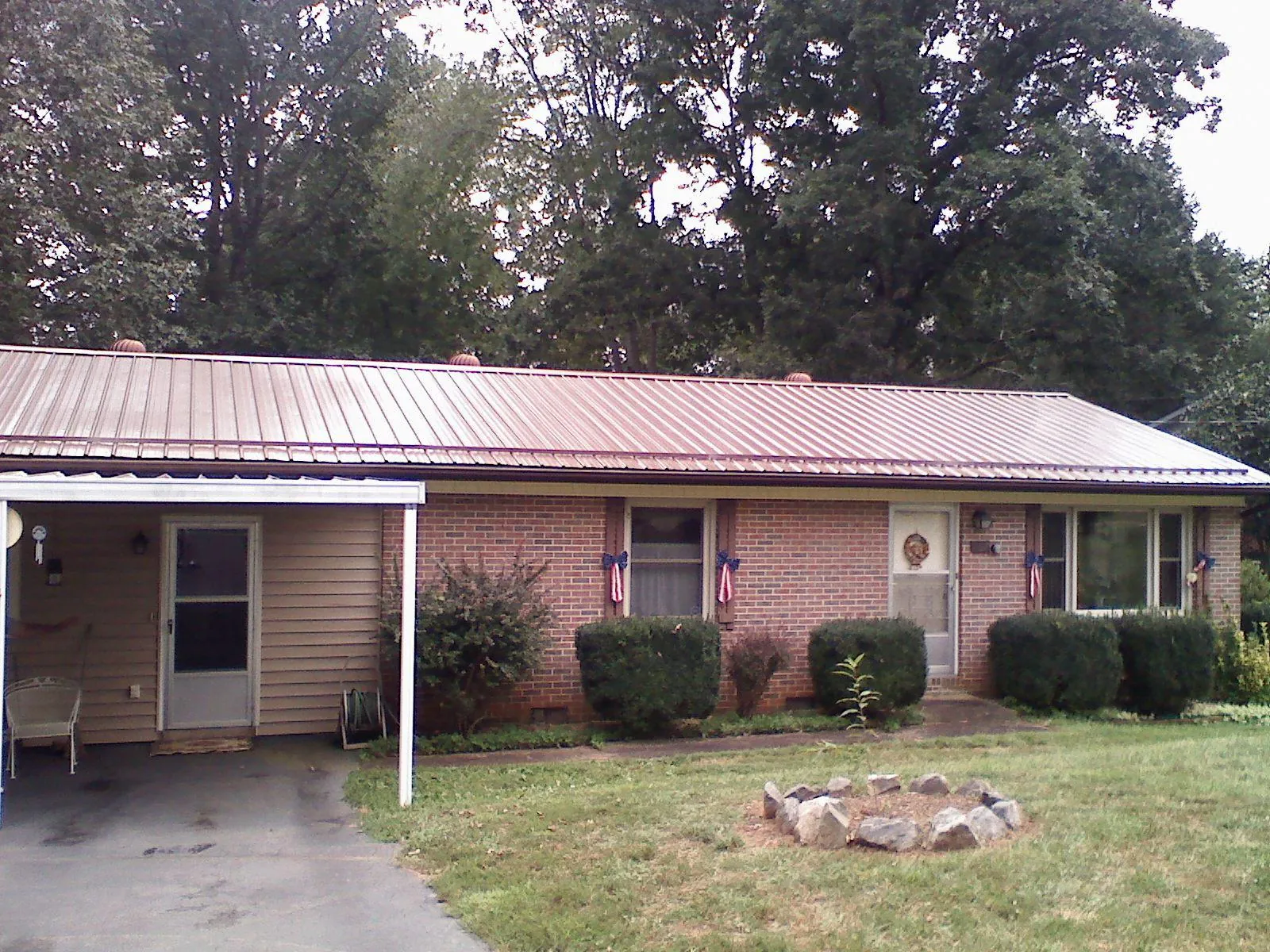 Bronze metal roof and carport on a brick ranch home — Roof Repair work by our crew in Colonial Beach