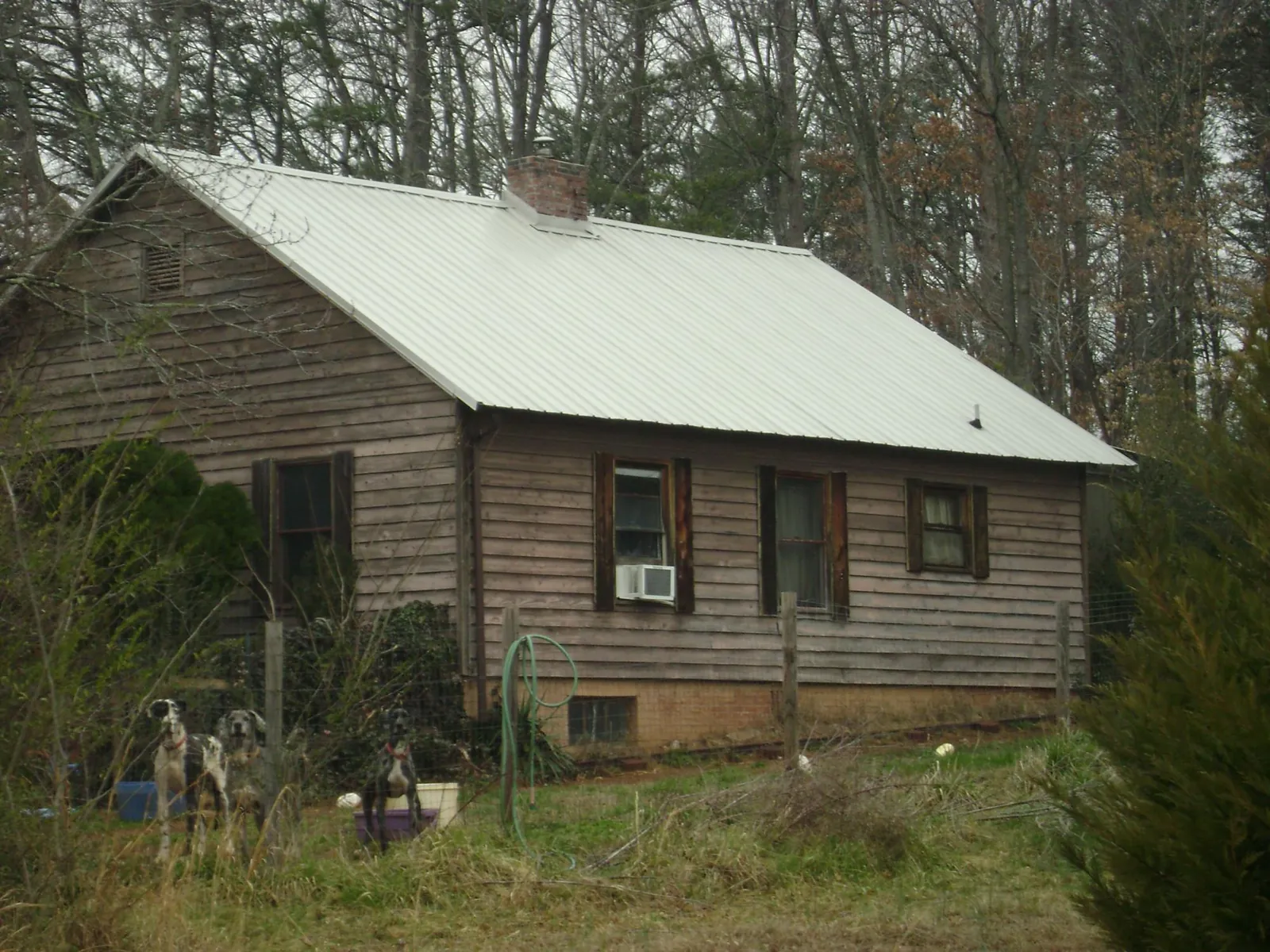 White metal roof on an old wood sided farmhouse, from a Metal Roof Installation job in Colonial Beach